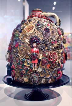 an elaborately decorated vase on display in a glass case