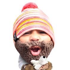 a young child wearing a knitted hat and holding a stuffed animal in his hands