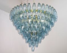 a chandelier made out of blue glass bottles hanging from a ceiling fixture in a room