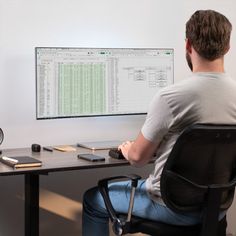 a man sitting at a desk in front of a computer monitor