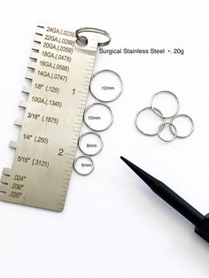 a pair of scissors, measuring tape and metal rings on top of a piece of paper