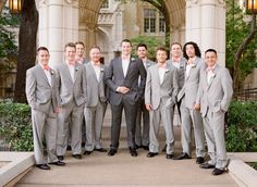 a group of men standing next to each other in front of a building with columns