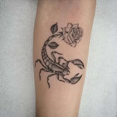 a scorpion and rose tattoo on the leg