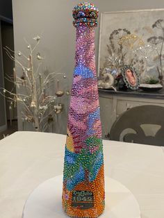 a colorful vase sitting on top of a table covered in lots of beads and stones