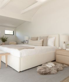 a bedroom with a white bed and two nightstands