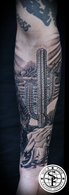 a man's arm with tattoos on it and an image of a cactus in the background