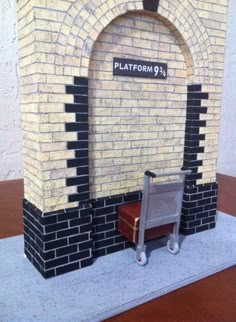 a miniature chair sitting in front of a brick wall with a sign that reads platform 9