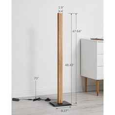 the floor lamp is made from wood and has a wooden pole on one side, with an electrical outlet in the middle