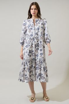 Arrive looking extra cute in the Bryony Floral Zinnia Split Neck Midi Dress! It features a button up detail in the front that forms lovely pleats across a V-neck bodice, long sleeves with elastic cuffs, drawstring waist and a tiered hem midi skirt. Wear some heels to go along this dress. - Split neck- Puff sleeves- Adjustable waist- Pockets- Color: Brown BluSize + Fit - Model is 5'8" and wearing size XS- Measurements taken from size S - Chest: 20"- Length: 48 1/2" Fabric Self:100%Cotton, Lining: Ruffle Hem Button-up Dress For Daywear, Flowy Buttoned Dress For Garden Party, Button-up Ruffle Hem Dress For Daywear, Button-up Dress With Ruffle Hem For Daywear, Daywear Button-up Dress With Ruffle Hem, Feminine Pleated Hem Dress For Daywear, Midi-length Pleated Hem Dress For Day Out, Flowy Brunch Dress With Button Closure, Casual Pleated Hem Dress For Brunch