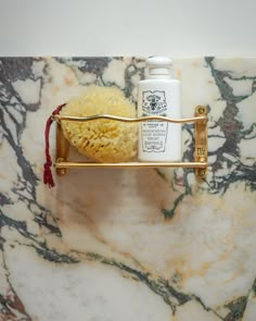 a marble counter top with soap, lotion and scrubs on the shelf next to it