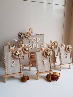 small wooden eases with flowers on them sitting in front of a sign that says top table