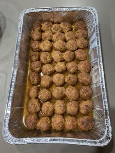 a metal pan filled with meatballs covered in sauce