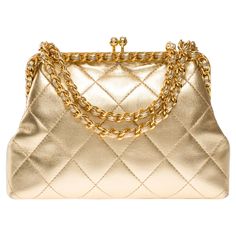 Extremely​ ​Rare​ ​Chanel​ ​shoulder​ ​bag​ ​in​ ​metallic​ ​gold​ ​quilted​ ​leather,​ ​gold​ ​metal​ ​trim,​ ​golden​ ​metal​ ​handle​ ​interlaced​ ​with​ ​gold​ ​leather​ ​for​ ​carrying​ ​hand​ ​or​ ​shoulder​ ​or​ ​crossbody​ ​carry Mechanical​ ​opening​ ​by​ ​golden​ ​metal​ ​balls Metallic​ ​gold​ ​leather​ ​interior​ ​lining,​ ​one​ ​zippered​ ​pocket Signature:​ ​"Chanel®Made​ ​in​ ​Italy" Date:​ ​1994/1996 Dimensions:​ ​18x12x5​ ​cm​ ​(7,1x4,7x2​ ​Inches) Chain​ ​length:​ ​57​ ​cm​ ​(22.5​ ​Inches) Reference:​ ​101986 General​ ​condition:​ ​7.5/10 Sold​ ​with​ ​hologram​ ​and​ ​authenticity​ ​card In​ ​excellent​ ​vintage​ ​condition​ ​despite​ ​minor​ ​wear​ ​marks​ ​on​ ​leather​ ​(scratches,​ ​patina),​ ​interior​ ​(wear)​ ​and​ ​trim​ ​(scratches) Vintage Chanel Bag, Chanel Brand, Chanel Shoulder Bag, Togo Leather, Metal Trim, Handbag Straps, Vintage Chanel, Quilted Leather, Gold Leather