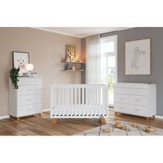 a white crib and dresser in a room