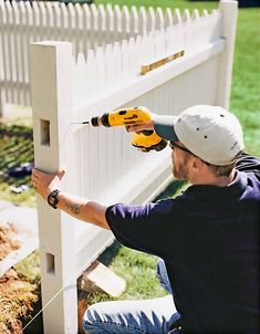 a man with a driller on his head working on a white picket - fence