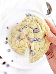 a person is holding a cookie with sprinkles on it