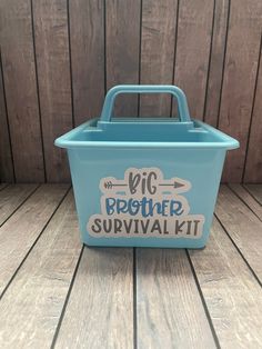 the big brother survival kit is sitting on a wooden floor with wood planks in the background