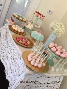 a table topped with lots of cupcakes and cakes