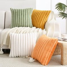 a white couch with four different colored pillows on it