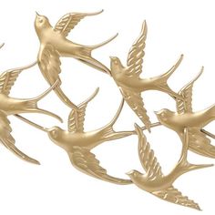 three gold birds are flying in the air with one bird on its back and another bird on it's side