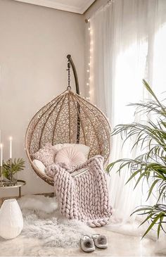 a room with a hanging chair and some plants