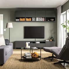 a living room filled with furniture and a flat screen tv mounted on a wall above a coffee table