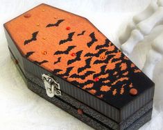 an orange and black box sitting on top of a white surface with bats painted on it