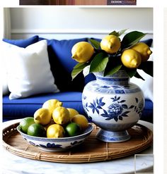 a blue and white vase filled with lemons on top of a table next to a bowl of limes