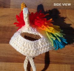 there is a crocheted toy that looks like a unicorn's head with multicolored hair