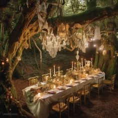 an outdoor dinner table with chandeliers hanging from the trees and candles on it