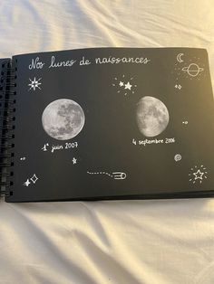 a notebook with drawings on it sitting on a bed