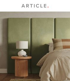 a bed with a green headboard next to a night stand