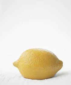 a lemon sitting on top of a white table