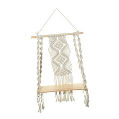 a white macrame hanging on a wooden shelf