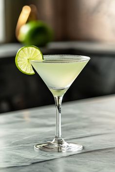 a martini glass with a lime slice on the rim