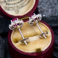 This lovely earrings are each centered with one (1) oval cut ruby in a four-prong setting. The rubies are each bordered with twelve (12) prong-set round brilliant cut diamond accents. The earrings measure 10.2mm long by 9.2mm wide and are 6.5mm deep.  They are finished with posts and friction backs. Ruby Earrings, Lovely Earrings, One 1, Diamond Halo, Round Brilliant Cut Diamond, Brilliant Cut Diamond, Halo Diamond, Oval Cut, Round Brilliant