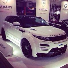 two white cars are on display in a showroom