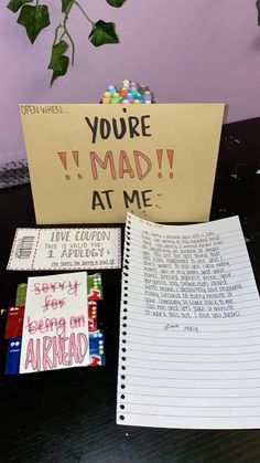 a notepad sitting on top of a table next to an open notebook with candy written on it