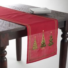 a red table runner with christmas trees on it