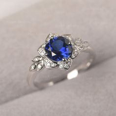 ◆The ring draws inspiration from the polaris. Hand-finished in Sterling sliver, this piece features a round shaped sapphire. Clear zirzons decorate around the main stone. An extremely simple celestial ring that you cannot miss. ◆ Production Description: Main stone Type: Lab Sapphire Main Stone Shape: Round Main Stone Size:7*7mm(1.66ct) Side stone: CZ Metal: 925 Sterling silver - Other options available in the drop down menu ◆ Customization: √Free for Add Engraving √Other Metal Type Available √Ot Wedding Sapphire Ring With Silver Center Stone, Wedding Sapphire Ring With Stone Setting In Silver, Silver Sapphire Ring With Stone Setting For Wedding, Sterling Silver Sapphire Ring For Wedding With Intricate Design, Silver Sapphire Ring With Intricate Design, Leaves Engagement Ring, Rings Sapphire, Green Sapphire Ring, Celestial Ring