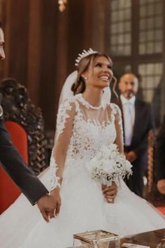 the bride and groom are smiling at each other as they stand in front of their guests