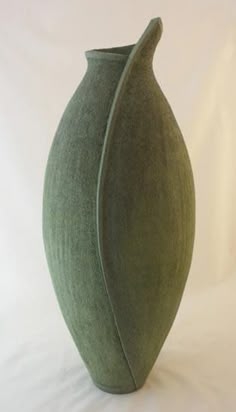 a green vase sitting on top of a white table