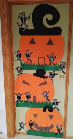 a door decorated for halloween with pumpkins and skeletons