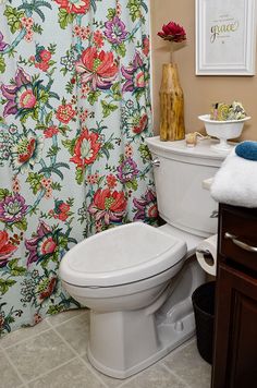 a white toilet sitting in a bathroom next to a shower curtain