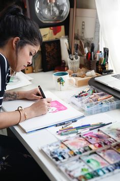 a woman sitting at a desk writing on a piece of paper