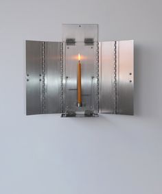 a candle is lit in the middle of a mirror