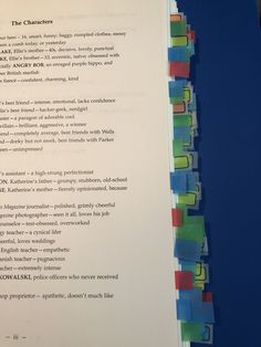 a close up of a book with many different colored pieces of paper on top of it