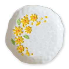 a white plate with yellow flowers painted on it