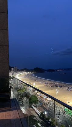 a balcony overlooking the beach and ocean at night