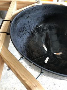 a large black bowl sitting on top of a wooden table